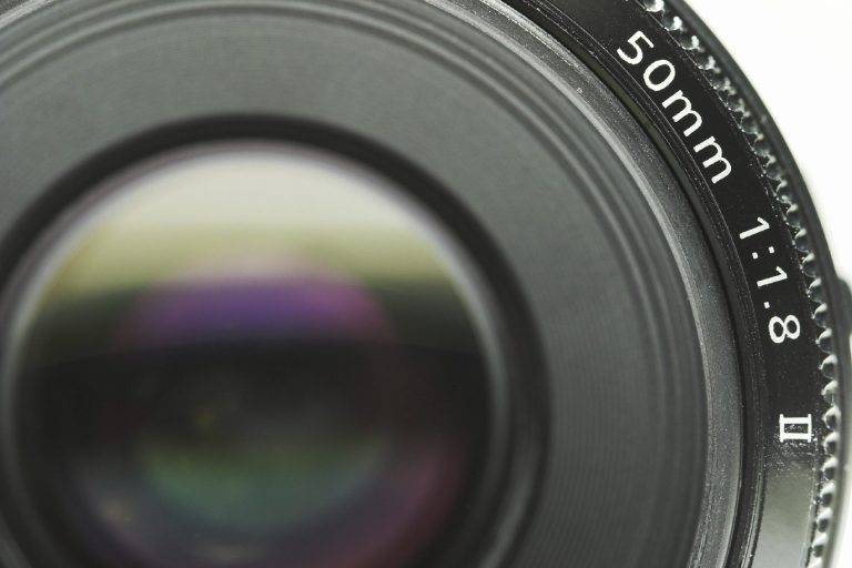 Close-up of a camera lens featuring a 50mm focal length and aperture setting.