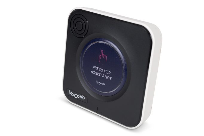 A sleek, square device with a circular button and a speaker, designed for assistance.